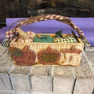 Distressed wooden basket with apples 🍎 on side and three small pillow accents.